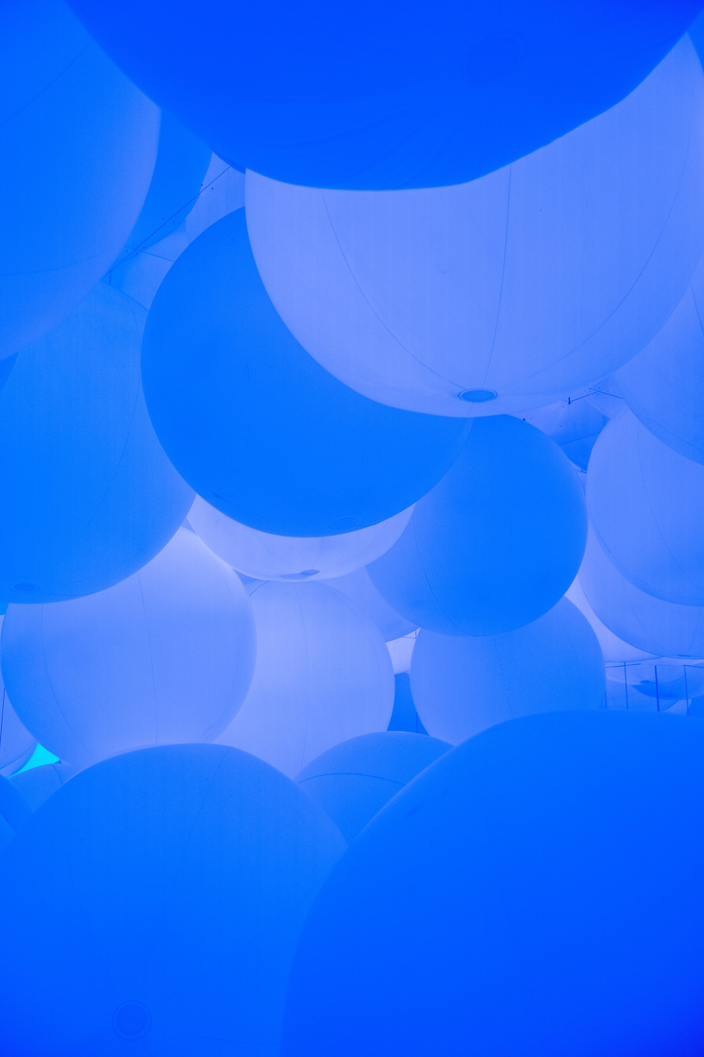 Illuminated blue sphere art installation glowing against dark background